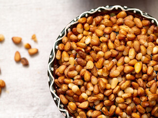 A bowl with peeled yellow Siberian pine nuts.