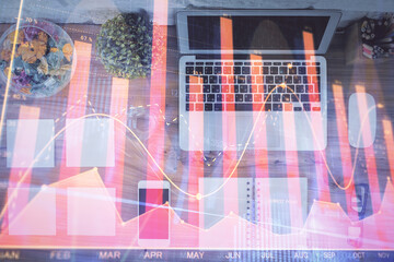 Stock market graph and top view computer on the table background. Multi exposure. Concept of financial education.