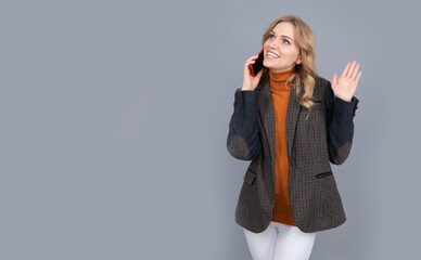 Happy woman in casual fashion style talk on mobile phone grey background copy space, conversation