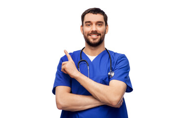 healthcare, profession and medicine concept - happy smiling doctor or male nurse in blue uniform with stethoscope pointing finger to something over white background - Powered by Adobe