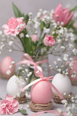 Happy easter! Painted pink eggs with pink flowers - tulips and carnations. Selective focus. 