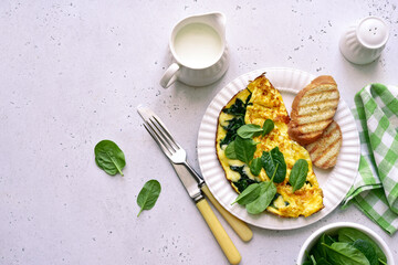 Omelet stuffed with spinach and cheese. Top view with copy space.