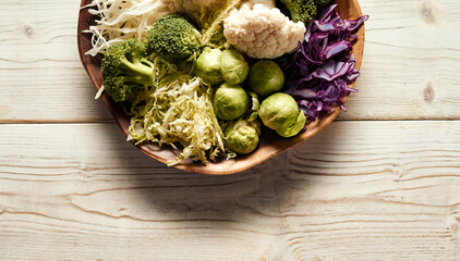 Bowl with cabbages on wooden table