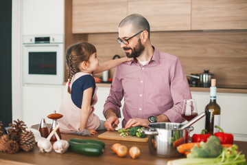 Man and his little daughter in the kitchen