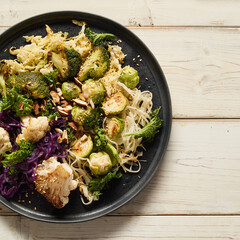 Tasty grilled various cabbages and noodles on plate on table