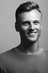 Fabulous at any age. Portrait of handsome 30-year-old man standing over gray background. Close up. Classic style. Shiny white smile. Headshot. Studio shot