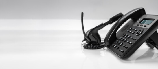 close up telephone devices with copy space background at office desk for customer service support, call center concept