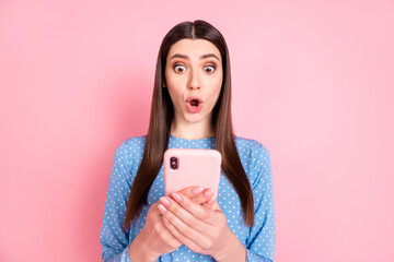 Photo of young shocked amazed surprised girl see dislike bad comment in smartphone isolated on pink color background