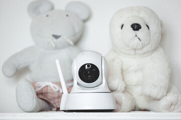 IP camera on the shelf with toys, serving as baby monitor