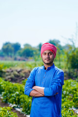 Naklejka na ściany i meble Young indian farmer standing at green chilly field