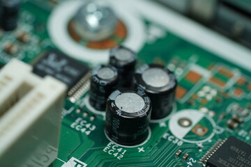 Stack of black capasitors on green motherboard
