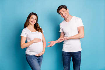 Photo portrait of two people husband showing wife pregnant belly waiting for child birth isolated vibrant blue color background