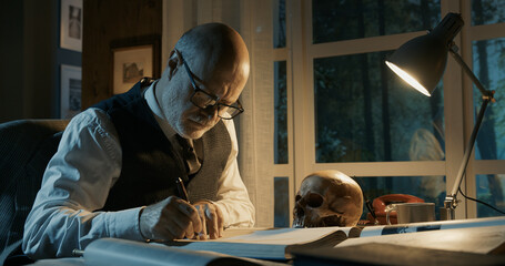 Academic professor studying a human skull - obrazy, fototapety, plakaty