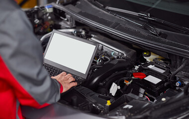 Obraz premium Mechanic using laptop during car engine diagnostic