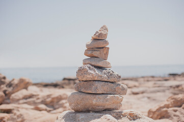 Fototapeta na wymiar Balanced stones on a pebble beach. Brown color filter