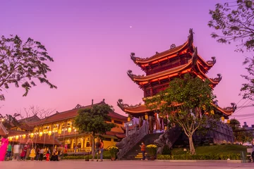 Fotobehang Fluor Roze Mooie traditionele decoraties en details op het dak van de tempel in het Vinh Nghiem-klooster met veel bezoekers in Ho Chi Minh-stad, Vietnam  © CravenA