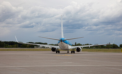 Passanger plane lands. Blue airplane on the platform of Airport. Runway. Landing aircraft.