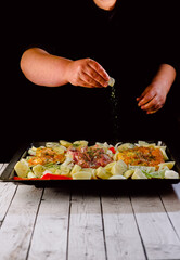 cook marinating the chicken thigh in the oven. Top view. on a baking sheet.