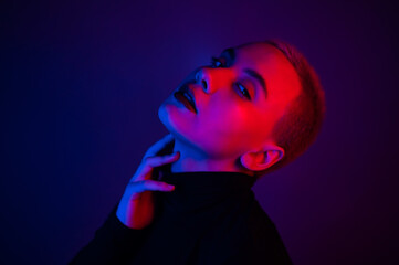 Portrait of a beautiful young woman with short hair in neon light