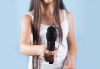 Girl with a microphone on a blue background.