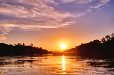 Fototapeta na wymiar Magic atmosphere of a romantic evening; golden sunset on the river