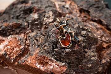Decoration in the form of a dancing pair of bronze and amber on a wooden background close-up