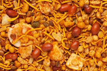 Hot spicy NavRatan mixture  snacks in full-frame, made with, potato chips, peanuts, besan sev, red chili. Pile of Indian spicy snacks (Namkeen), Top  view.
