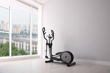 Elliptical machine cross trainer near window indoors