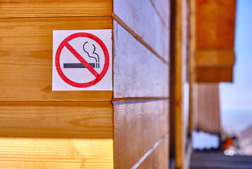 No smoking sign on the wall of a wooden house