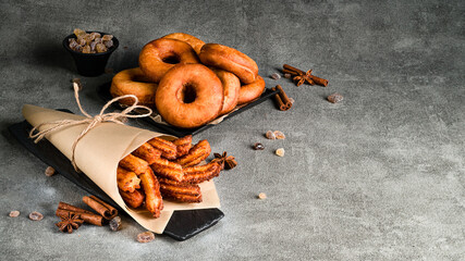 Churros in a paper bag with sugar on dark background. pastry churros and donuts copy space