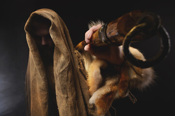 Portrait of a medieval bearded military monk, dressed in animal skins and burlap, holding a battle ax. Low key. Focus on your clothes. Atmospheric portrait of a character from a RPG game