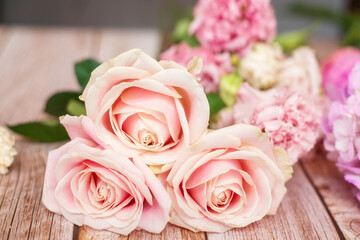 Close-up of different pastel roses in a bouquet on the table at the florist