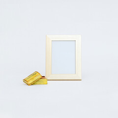 Closeup of empty golden frame mockup next to a jewelry box isolated on white background