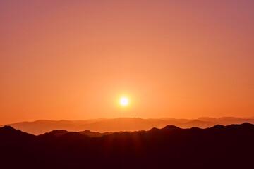 Rising sun over the mountain ridges as a background