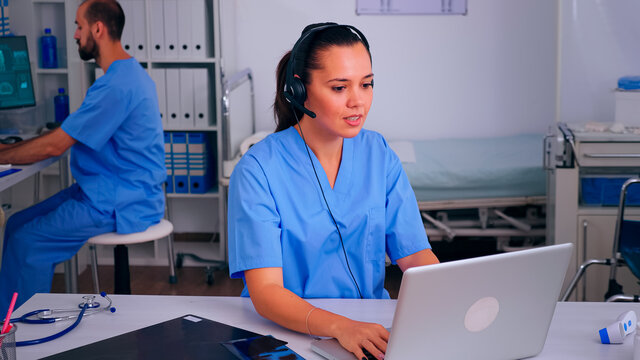 Assistant Offering Medical Online Services Using Headphone Answering Calls, Making Appointments. Hospital Call Center Healthcare Physician In Medicine Clinic, Receptionist Doctor Nurse Helping With