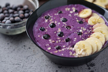 Smoothie porridge for breakfast with banana and blueberries in a bowl