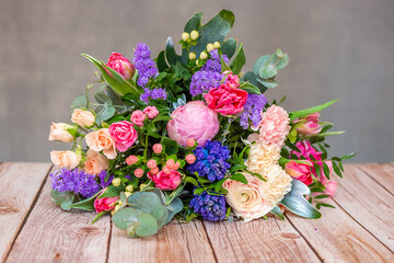 Close up view of a beautiful bouquet of mixed coloful flowers on wooden table.