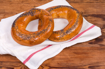 Two poppy seed ring-shaped bread rolls on a napkin