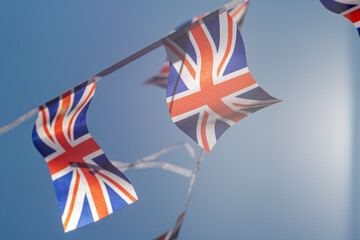 Great Britain British Flag pennants buntings isolated on blue background  for your text flag of great britain evolving in the wind Coronation of Charles III and Camilla - obrazy, fototapety, plakaty