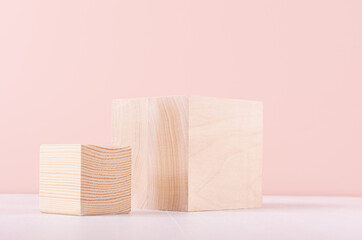 Gentle eco showcase with set wooden cubes as podiums on white board and pink wall for cosmetics product display.