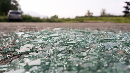 broken car window glass on the ground at a parking lot
