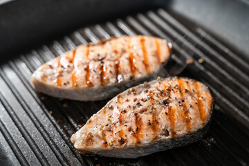 Grilled salmon fish on pan on the flaming grill