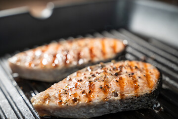 Roasted salmon steaks in a frying pan, view from above