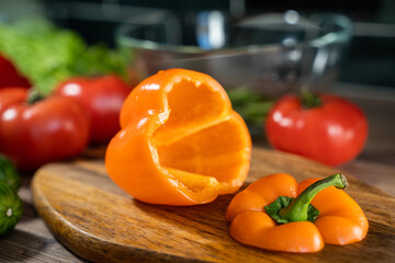 Cutting board and vegetables on wooden background