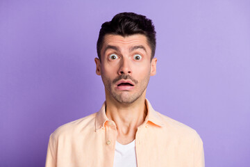 Photo of frightened horrified guy staring open mouth wear beige shirt isolated violet color background