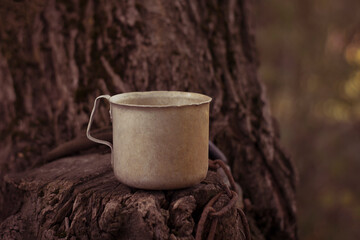 Aluminium mug. It's on the sawing of a tree. The front view is in nature.