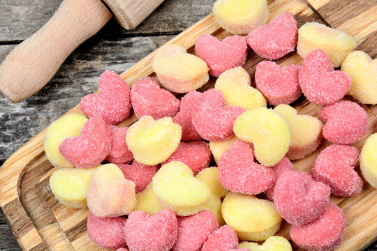 Colorful gnocchi hearts on a old table with rolling pin