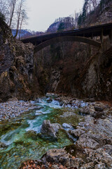 beautiful landscape with a mountain river with small waterfalls in winter day in the canyon.