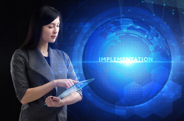 Business, Technology, Internet and network concept. Young businessman working on a virtual screen of the future and sees the inscription: Implementation