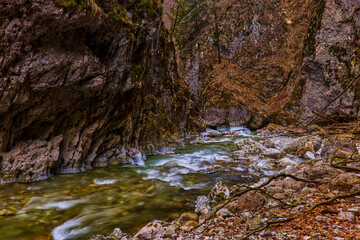 beautiful landscape with a mountain river with small waterfalls in winter day in the canyon.